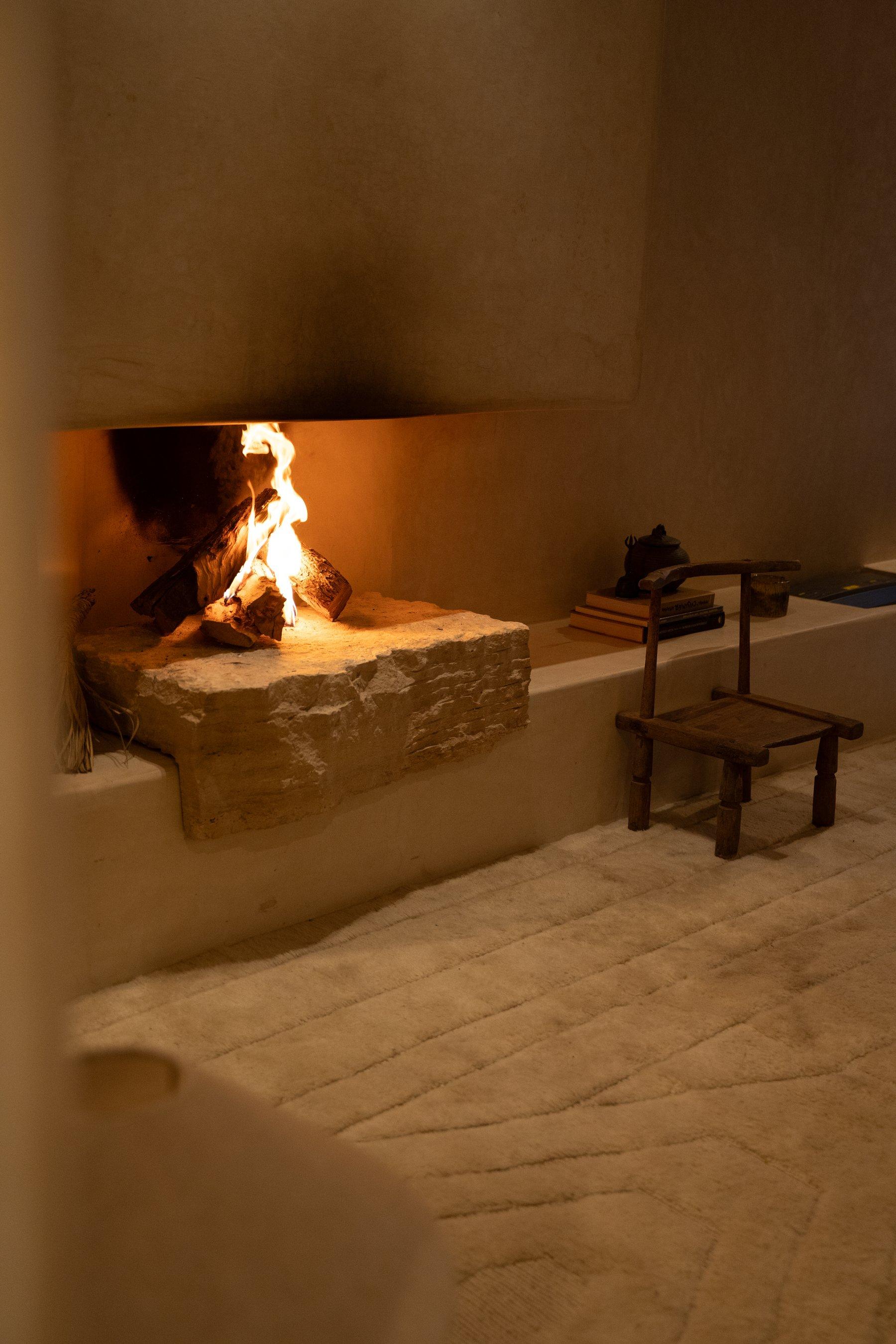 Intérieur à Marrakech, feu allumé dans une cheminée de plâtre